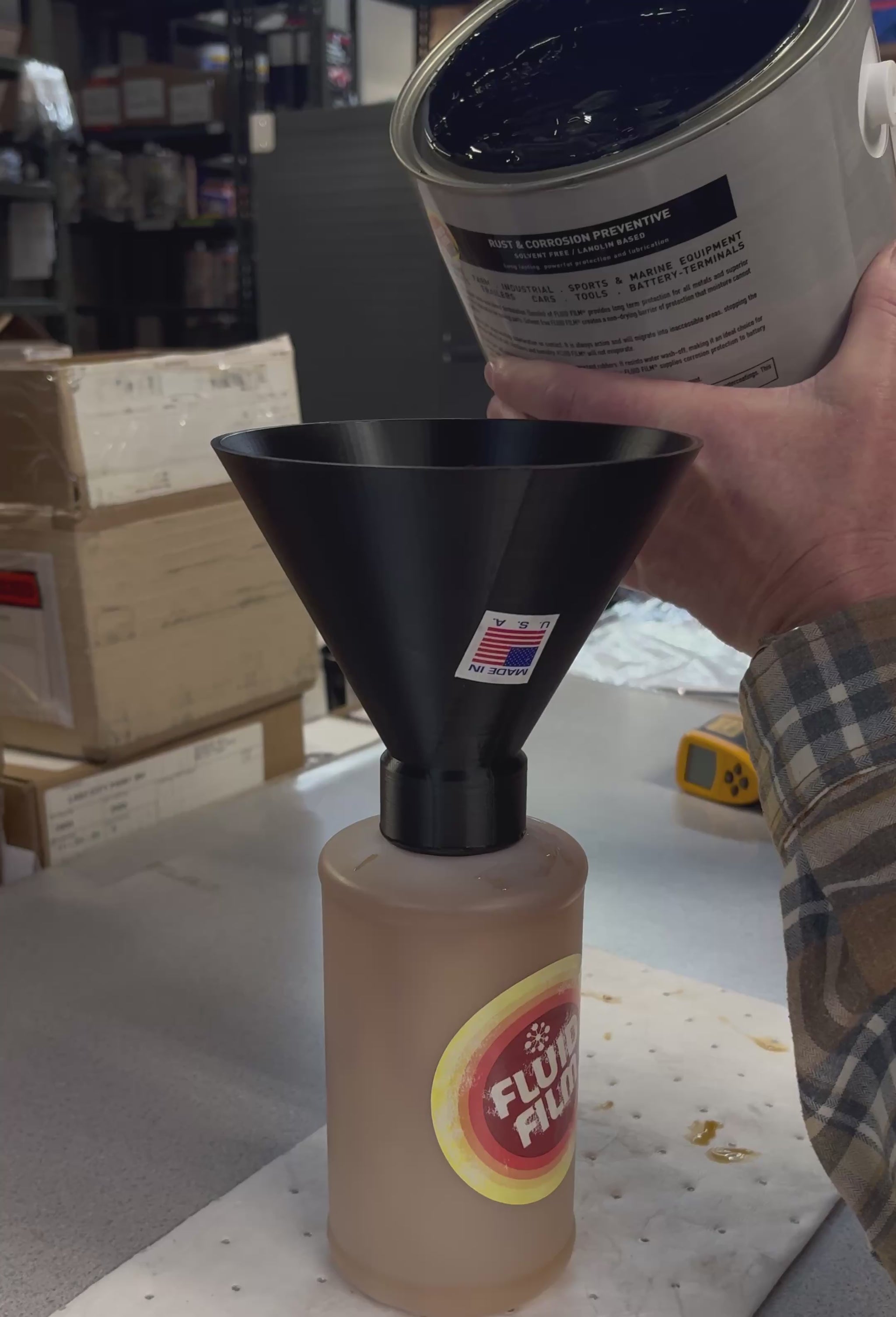 Pouring undercoating fluid into funnel bottle for spray gun application and automotive rust prevention